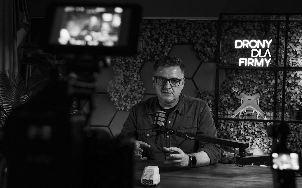 Nagranie w studiu: dwie kamery z podglądem, mikrofon na ramieniu i neon z logo klienta